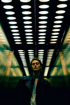 a man is standing in an elevator with his head turned to the side and eyes closed