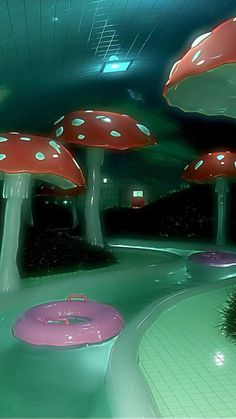 several mushroom like structures in the middle of a green area with pink and white bases