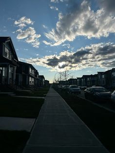 the sun is setting over some houses and cars