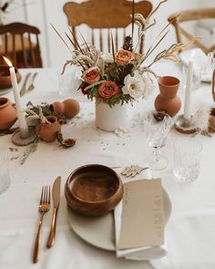 a table set for dinner with flowers and candles