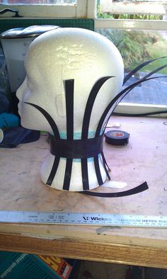 a white mannequin head with black strips on it