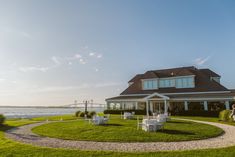 an outdoor wedding venue near the water with chairs and tables set up in front of it