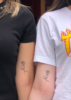 two girls with matching tattoos on their arms