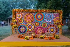 an outdoor stage decorated with flowers and oranges for a wedding or reception ceremony at the park