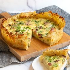 a quiche on a cutting board with a slice missing