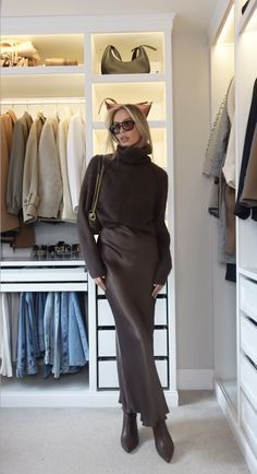 a woman standing in front of a closet full of clothes