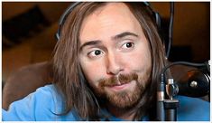 a man with long hair wearing headphones and looking at the camera while sitting in front of a microphone