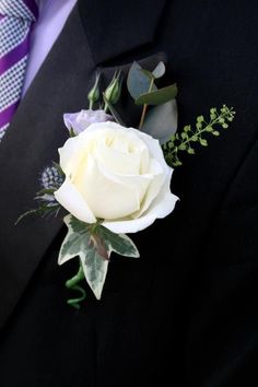 a man in a suit with a white rose on his lapel