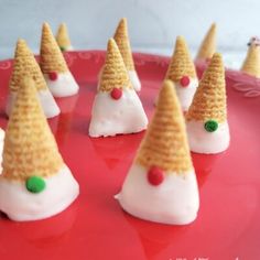 small cones with candy on them sitting on a red plate