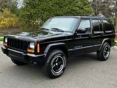 a black jeep is parked in a parking lot