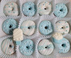 blue and white donuts are arranged on a paper plate with frosting sprinkles