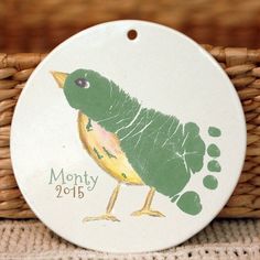 a ceramic ornament with a green bird on it's back and the words month of birds