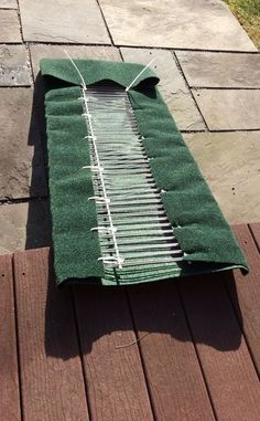 a green tarp laying on top of a wooden floor next to a brick walkway