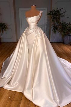 a white wedding dress on display in a room