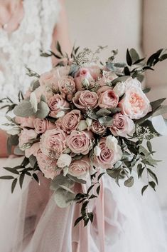 a bridal holding a bouquet of pink roses