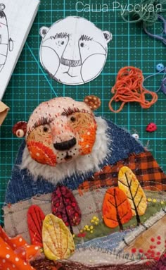 the bear is made out of fabric and other crafting supplies on top of a cutting board