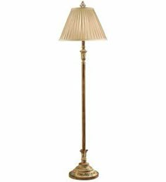 a floor lamp with a beige shade on it's side and a white background