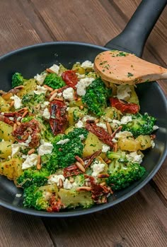 broccoli and other vegetables are mixed together in a bowl with a spoon on the side