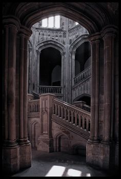 the interior of an old building with stairs and arches