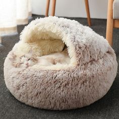 a cat sleeping in a pet bed on the floor