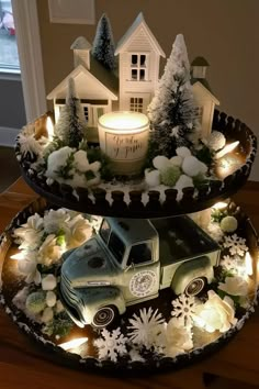 two tiered trays filled with christmas decorations and lit candles on top of a table