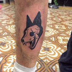 a man's leg with a tattoo of a dog head on the side of his leg