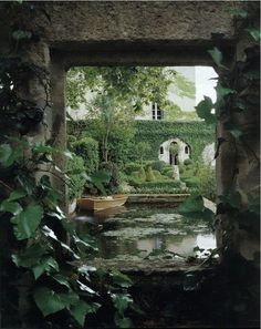 an open doorway leading to a garden with water and trees in the foreground, surrounded by greenery