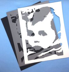 two pieces of paper cut to look like the face of a man