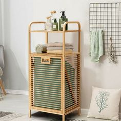 a bamboo shelf with towels, soaps and other items on it in a white room