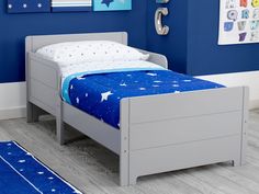 a child's bed with blue and white stars on the sheets is shown in this image