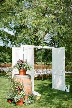 an outdoor ceremony setup with chairs and tables in the background, surrounded by greenery