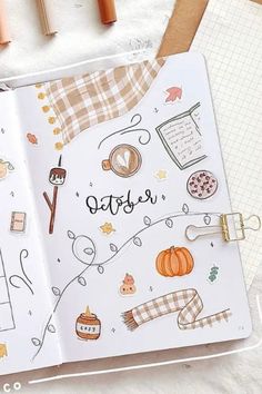 an open notebook with the word october written on it and some other items around it