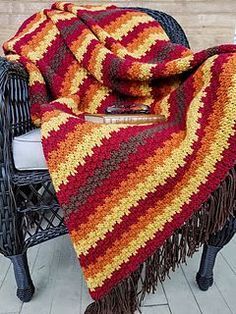 a crocheted blanket sitting on top of a chair