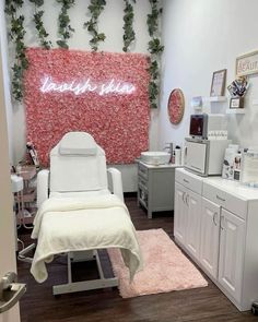 a salon room with white furniture and pink flowers on the wall