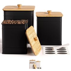 three black containers with wooden lids and spoons next to each other on a white background