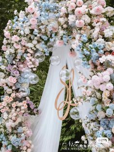 a wedding arch decorated with flowers and balloons