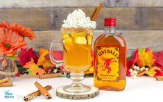 a glass mug filled with ice cream and cinnamon sits next to a bottle of fireball cider