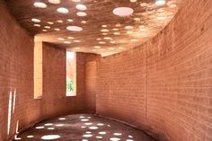 an empty room with lots of spots on the ceiling and walls, in front of a brick wall