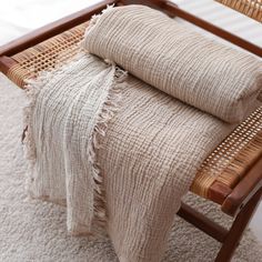 two woven blankets are sitting on a chair in the middle of carpeted flooring