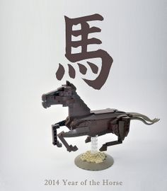 a horse made out of legos sitting on top of a white table next to a chinese symbol