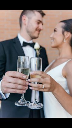 a bride and groom holding champagne flutes in their hands