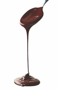 a spoon full of melted chocolate on a white background