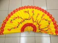 a yellow and red fan sitting on top of a tiled floor