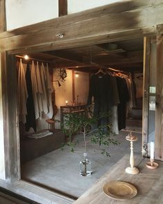 a room that has some clothes hanging on the wall and two candles in front of it