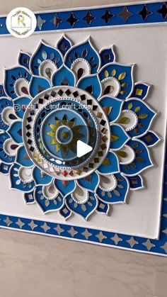 a blue and white card with an intricate design on the front, featuring a circular flower