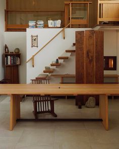 a wooden table sitting in front of a stair case