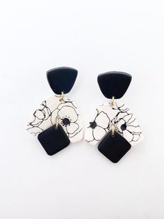 two black and white earrings with flowers on them