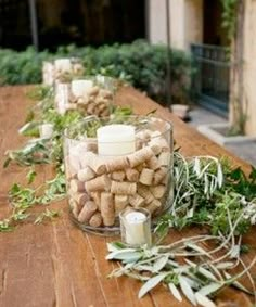 there are many candles that are on the long table with wine corks in it