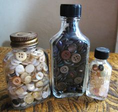 two bottles filled with buttons sitting on top of a table