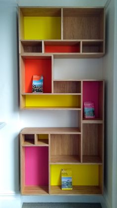 an empty room with some shelves and boxes on the wall next to each other in different colors